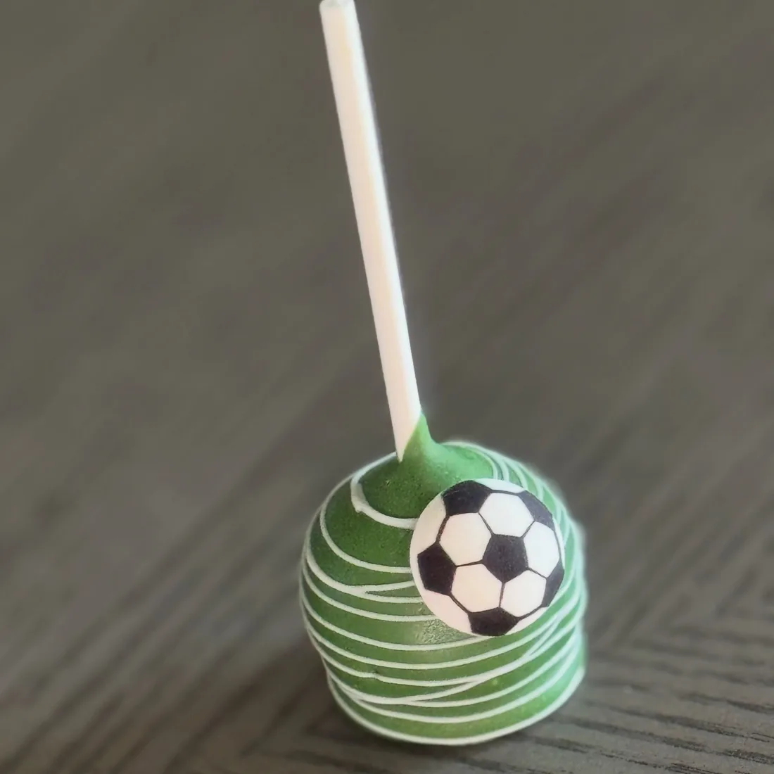 Green striped cake pop decorated with a fondant soccer ball