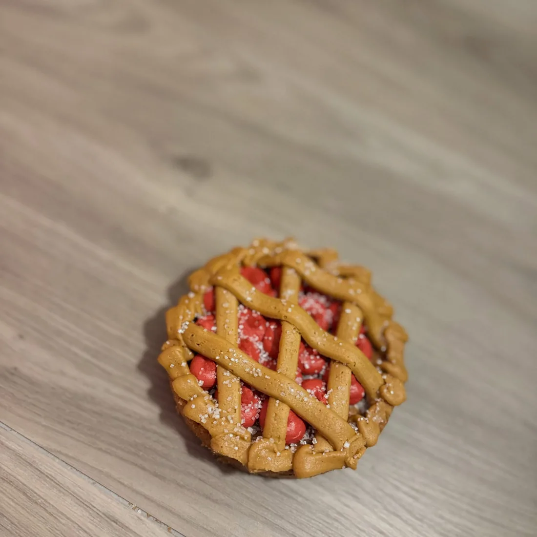 A single mini cherry cookie pie with a piped buttercream lattice