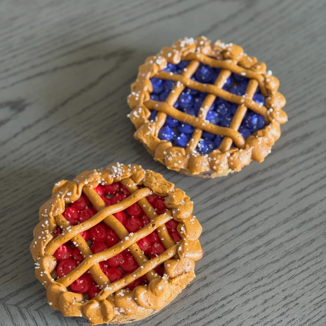 A blueberry and a cherry mini lattice cookie pie side by side