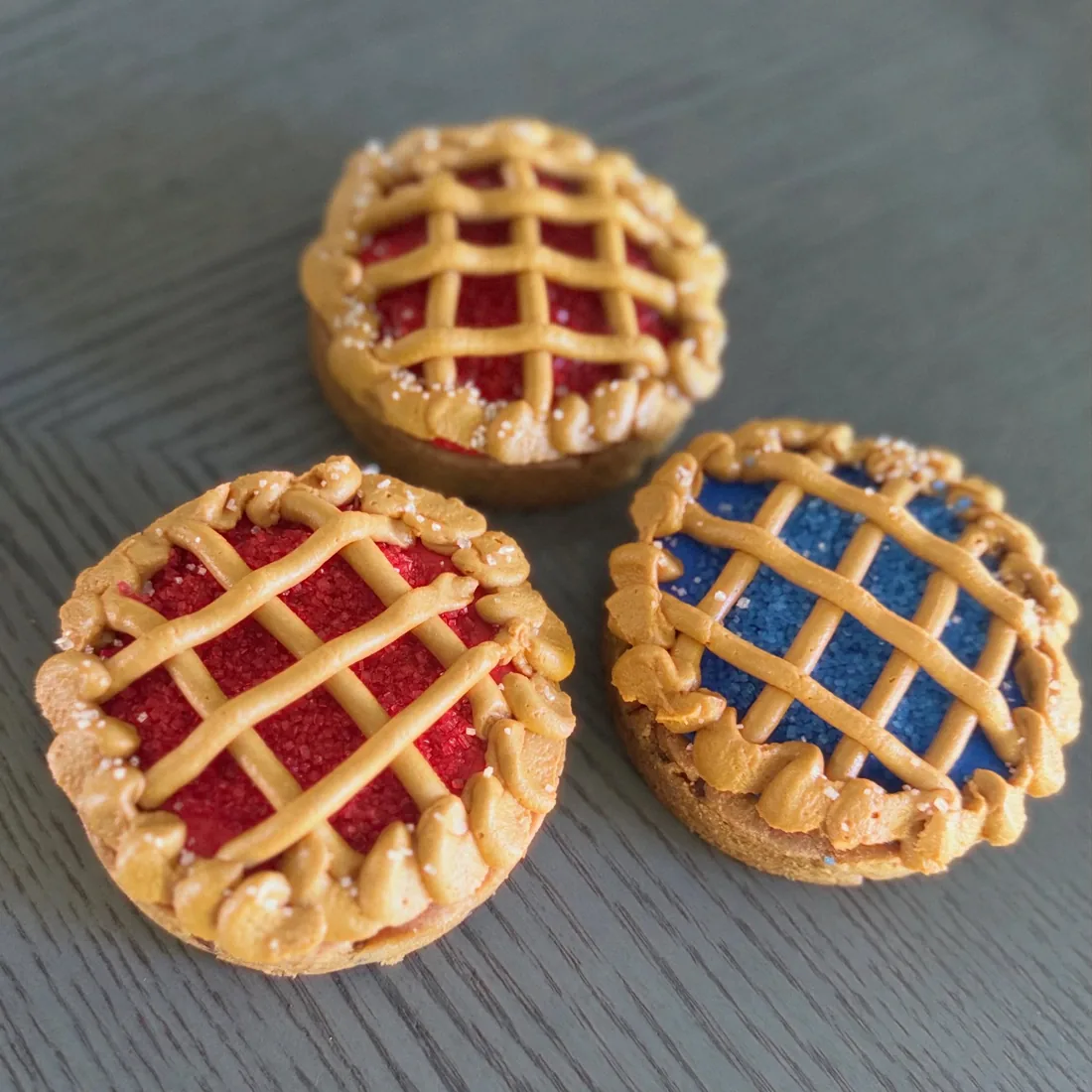 Three mini lattice cookie pies filled with cherry and blueberry