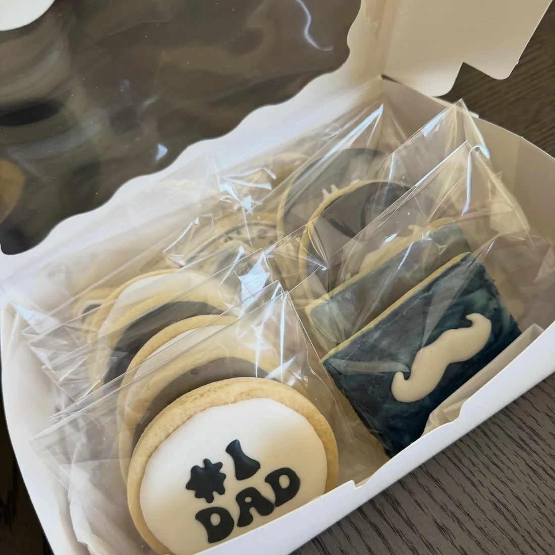 Gift box of individually wrapped Father's Day cookies including #1 Dad and mustache designs