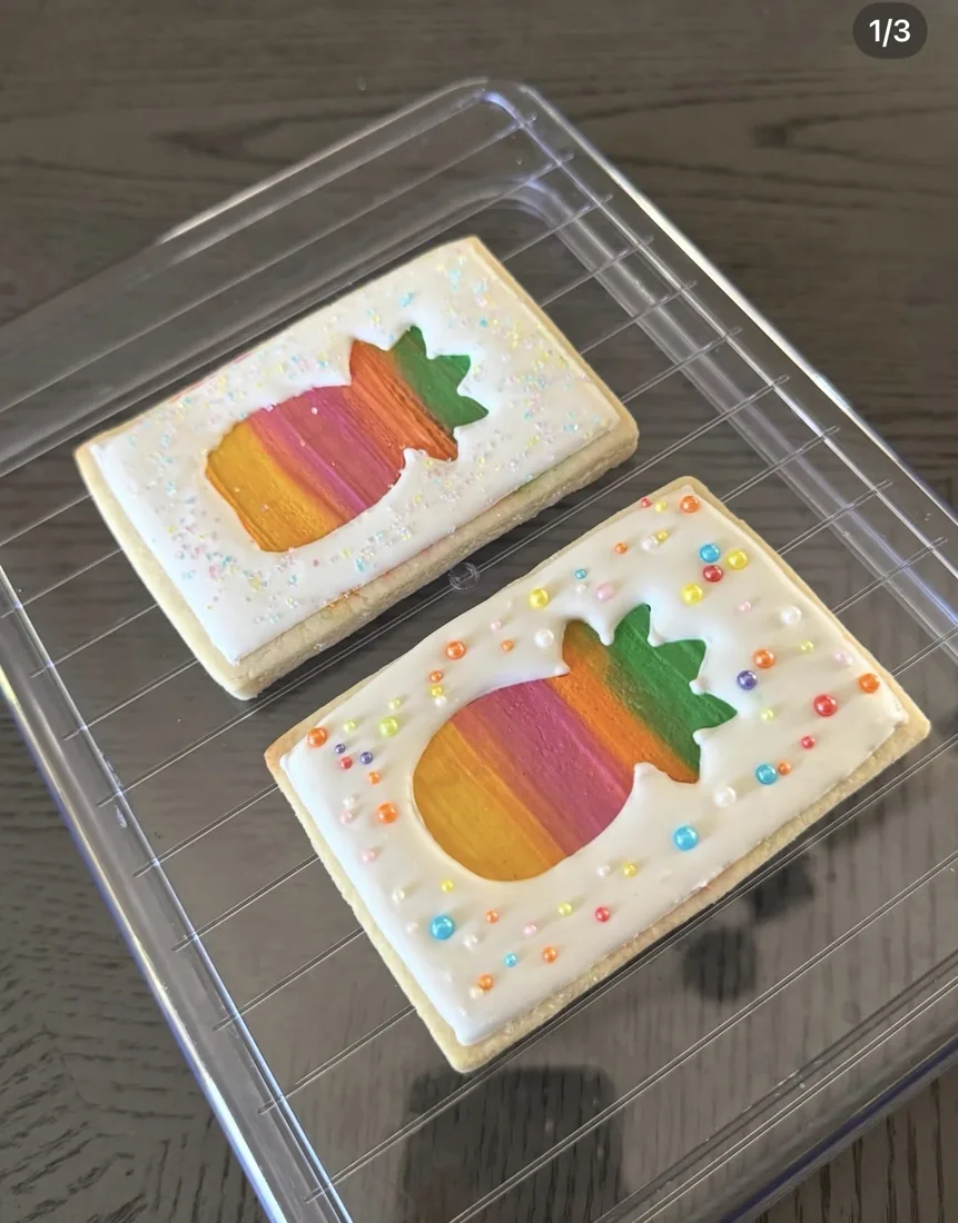 Two rectangle cookies with rainbow ombré pineapples and sprinkle pearls