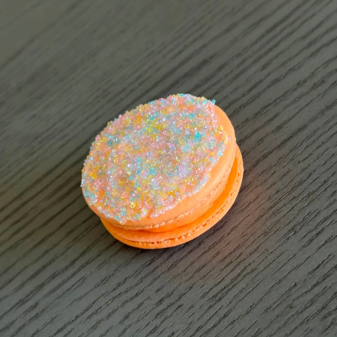 Orange macaron coated in iridescent sugar crystals