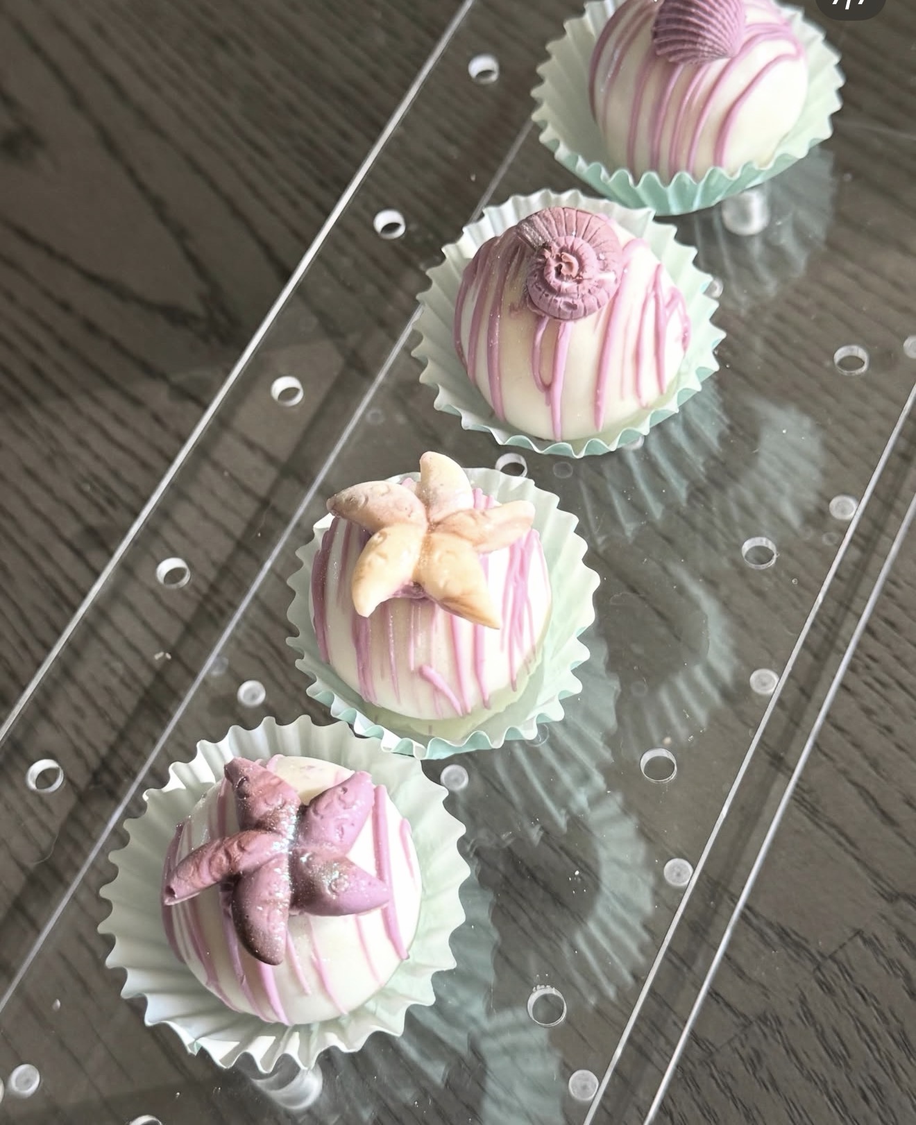 Ocean themed cake pops in mint cupcake cups, white chocolate with purple drizzle and sea life toppers
